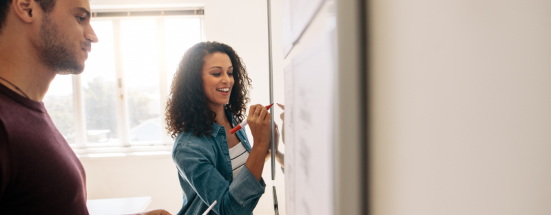 lady writing on whiteboard in red ink